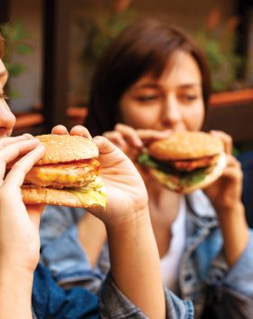 group-three-friends-enjoying-burgers