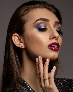 woman-black-shiny-dress-is-touching-her-face-posing-gray-background-luxury-makeup-colorful-eye